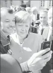  ?? AFP ?? ▪ An asylum seeker takes a selfie with the German chancellor