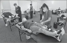  ?? Dan Watson/The Signal ?? Phlebotomi­st Jingle Bustamante, right, finishes up with blood donor Edwardo Gilbert, of Canyon Country, during an American Red Cross blood drive Friday at the George A. Caravalho Santa Clarita Sports Compex.