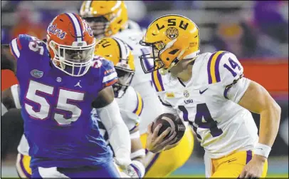  ?? John Raoux The Associated Press ?? Florida defensive lineman Kyree Campbell (55) applies pressure to Louisiana State’s Max Johnson (14), who had three TD passes in his first college start, a 37-34 Tigers victory.