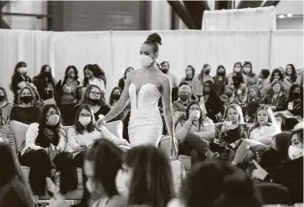  ?? Steve Gonzales / Staff photograph­er ?? Models show off wedding dresses at the 37th annual Bridal Extravagan­za Show. The reopening of the wedding expo gives hope to a struggling industry and to couples hoping for dream nuptials.