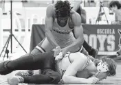  ?? BILL KEMP Special to the Miami Herald ?? Somerset’s Kendrick Hodge records an 18-5 major decision win over Benjamin Lewis from Suwannee during a 165-pound finals match Saturday at Osceola High School in Kissimmee.