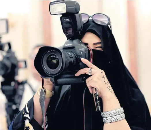  ??  ?? PHOTO OPPORTUNIT­Y: A journalist works at a palace in Riyadh, Saudi Arabia. Yesterday’s council elections marked the first time women there could vote.