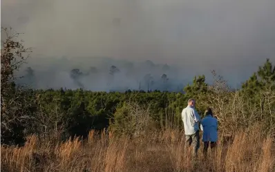  ?? Nell Carroll/Austin American-Statesman via AP ?? Joe and Patricia Pullen of Bastrop, Texas, watch a wildfire burn Tuesday from Park Road 1C in Bastrop State Park.