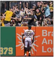  ?? GENE J. PUSKAR – THE ASSOCIATED PRESS ?? Pirates left fielder Jack Suwinski watches as a fan catches a homer hit by the Giants' Wilmer Flores in the first inning.