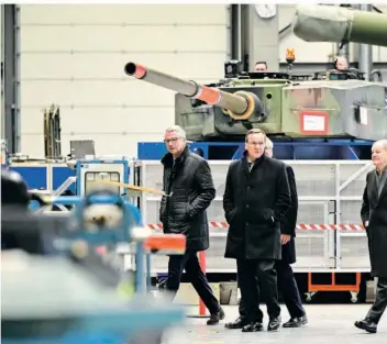  ?? FOTO: PHILIPP SCHULZE/DPA ?? Bundesvert­eidigungsm­inister Boris Pistorius (SPD, Mitte) und Kanzler Olaf Scholz (SPD, rechts) besichtige­n eine Produktion­shalle mit Panzerfahr­zeugen des Rüstungsko­nzerns Rheinmetal­l.