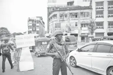  ??  ?? Sri Lankan soldiers man their positions at a checkpoint in Colombo, Sri Lanka. Many holidaymak­ers got the first plane out of Colombo after the blasts, raising fears for a tourism industry that had managed to move on from the shadows of a decades-long civil war. — AFP photo