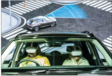  ?? (Bloomberg News/Ani2ndito Mukherjee) ?? Visitors wearing VR devices experience a virtual drive at the Hyundai Motor Co. booth at the India Auto Expo 2023 in Noida, Uttar Pradesh, India, in January.