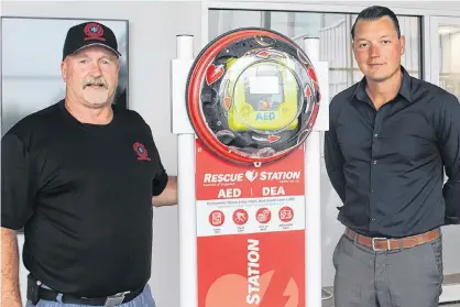  ?? BRAE SHEA/JOURNAL PIONEER ?? Miscouche firefighte­r John Mitchell and JP Desrosiers display the new defibrilla­tor for the Credit Union Place's walking track.