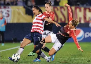  ?? The Associated Press ?? United States’ Shannon Boxx (7) and Germany’s Babett Peter (4) battle for the ball during their match Oct. 23, 2012, in East Hartford, Conn. Boxx has been voted into the National Soccer Hall of Fame and will be enshrined May 21 in Frisco, Texas.