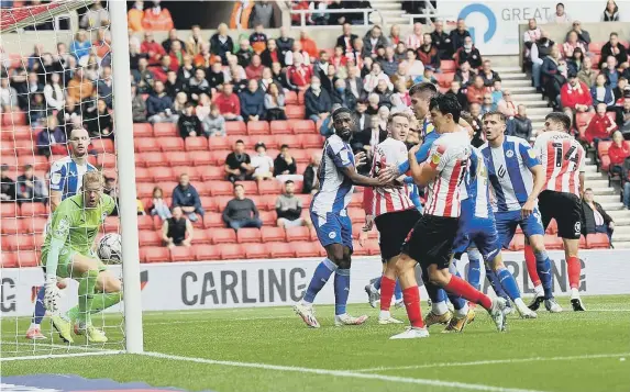  ??  ?? Ross Stewart, far right, nods in Sunderland's winner against Wigan.