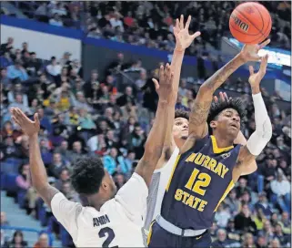  ?? [ELISE AMENDOLA/THE ASSOCIATED PRESS] ?? Murray State's Ja Morant (12) passes the ball under pressure from Marquette's Sacar Anim (2) and Brendan Bailey during Thursday's NCAA Tournament game in Hartford, Conn.