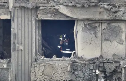  ?? DAN KITWOOD, GETTY IMAGES ?? A firefighte­r conducts a search of burned out flat in Grenfell Tower on Thursday in London, England.