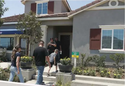  ?? (Nichola Groom/Reuters) ?? PROSPECTIV­E HOMEOWNERS tour a house in a new community in Jurupa Valley, California, last month.