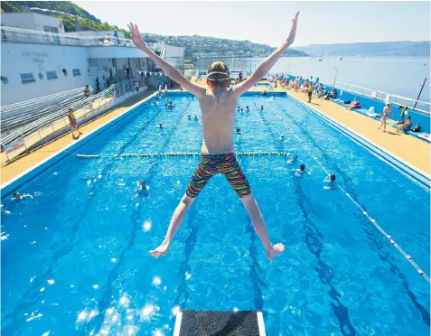  ??  ?? Daniel Mackintosh, 12, from Milngavie, takes the plunge into Gourock pool under a blazing sun on the coast of the Firth of Clyde as temperatur­es soared north of the border