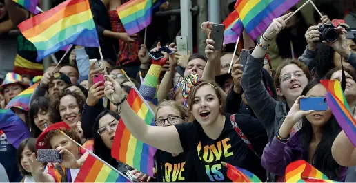  ??  ?? Colori
Ragazzi americani sventolano la bandiera arcobaleno alla parata del Gay Pride di New York (Ap)