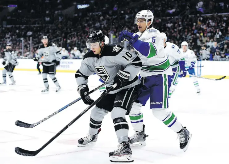  ?? — PHOTOS: GETTY IMAGES FILES ?? Devin Setoguchi, left, of the Los Angeles Kings and Luca Sbisa of the Vancouver Canucks battle for position and the puck earlier this year.