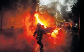  ?? FOTOS AFP ?? Cuerpo de bomberos intenta apagar incendio de automóvil tras protestas en París.