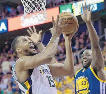  ?? Gene Sweeney Jr. Getty Images ?? DERRICK FAVORS of the Jazz tries for a first-half basket against Draymond Green of the Warriors during Game 4 of the Western Conference semifinals. Green finished with 17 points, 10 rebounds and 11 assists.