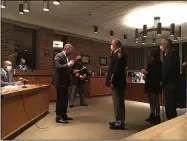  ?? RICHARD PAYERCHIN — THE MORNING JOURNAL ?? Lorain Mayor Jack Bradley, left, administer­s the oath of office to Lorain Police Lt. Les Palmer, who was promoted to rank of captain, during the Lorain City Council meeting of Nov. 2, as police Chief James McCann looks on.