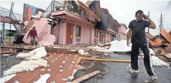  ?? SEAN GARDNER, GETTY IMAGES ?? A man walks through the debris of what was once a motel on Chef Menteur Highway after a tornado touched down in New Orleans. According to the weather service, 25 people were hurt.