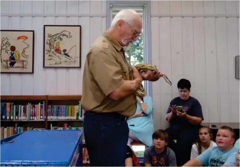  ?? (Submitted photo) ?? Herpetolog­ist Terry Vandevente­r shows a Chicken Snake at Kids Day at Maben Library.