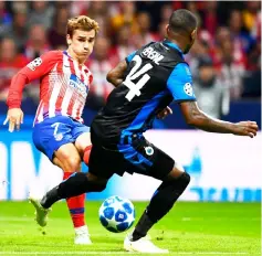  ?? — AFP photo ?? Antoine Griezmann (left) scores during the UEFA Champions League group A match against Club Brugge at the Wanda Metropolit­ano stadium in Madrid.