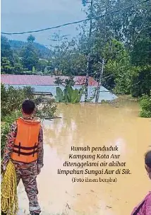  ?? (Foto ihsan bomba) ?? Rumah penduduk Kampung Kota Aur ditenggela­mi air akibat limpahan Sungai Aur di Sik.