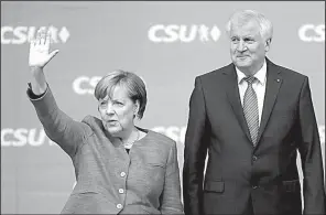  ?? AP/MATTHIAS SCHRADER ?? German Chancellor Angela Merkel arrives Friday for a campaign rally in Munich along with Bavarian state Gov. Horst Seehofer.