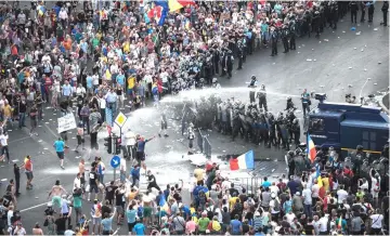  ??  ?? Riot police use water cannon against protesters in front of the Romanian Government headquarte­rs in Bucharest, Romania. — AFP photo