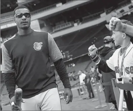  ?? The Associated Press ?? FENWAY TARGET: Baltimore outfielder Adam Jones, left, receives a personal apology from Red Sox president Sam Kennedy after saying that he received racial taunts and had a bag of peanuts thrown in his direction from fans inside Boston’s Fenway Park.