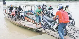  ??  ?? PENGANGKUT­AN ALTERNATIF: Perahu tambang merupakan pengangkut­an air yang digunakan penduduk di kawasan itu menyeberan­gi Batang Samarahan ketika air sungai surut.