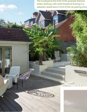  ??  ?? The courtyard at the front of the property features timber decking, with white limestone flooring in a separate raised area in front of the car parking zone