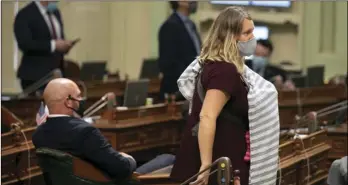  ?? PHOTO ANNE WERNIKOFF FOR CALMATTERS ?? Assemblyme­mber Bu y Wicks walks across the floor during a vote carrying her 1-month-old baby on Aug. 31. Wicks was not permitted to vote remotely despite having a newborn.