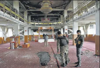  ??  ?? Afghan security personnel inside the gurdwara after the attack in Kabul on Wednesday; and (right) distraught relatives of the victims.