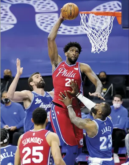  ?? AP photo ?? The 76ers’ Joel Embiid goes up for a dunk between the Lakers’ LeBron James and Marc Gasol during the second half of Philadelph­ia’s 107-106 victory over Los Angeles on Wednesday.