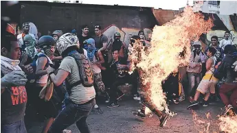  ?? FOTO: AFP ?? Imágenes muestran al joven envuelto en llamas en plena manifestac­ión de los opositores.