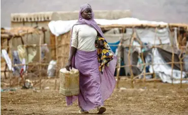  ?? Foto: AFP/Ashraf Shazly ?? Eine Frau holt Wasser in einem Lager für Binnenflüc­htling in der Provinz Süd-Kordofan, Sudan.