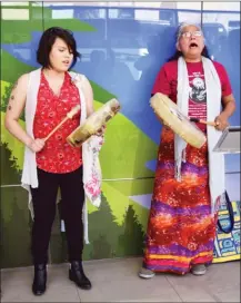  ?? STEVE MacNAULL/The Okanagan Weekend ?? Sacheen Lindley, left, and Pat Raphael Derrickson of the Westbank First Nation sing at Friday’s grand opening of the Cedar Sage Health and Wellness clinic at Interior Health headquarte­rs in downtown Kelowna.