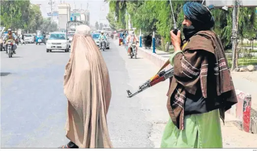  ?? EFE ?? Un talibán junto a una mujer ayer por las calles de Kandahar.