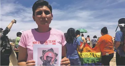  ??  ?? Gabriela Hernandez, executive director of the nonprofit New Mexico Dream Team, holds up an image in Albuquerqu­e last year of Roxsana Hernandez, a Honduran transgende­r woman who died while in U.S. custody.