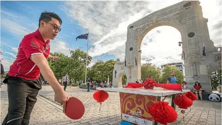  ?? PHOTO: JOHN KIRK-ANDERSON/FAIRFAX NZ ?? Ethan Lin battles Simon Fenwick, and a strong wind, at the opening of three table tennis tables near the Bridge of Remembranc­e.