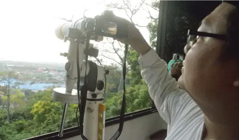  ?? UMAR WIRAHADI/JAWA POS ?? PENENTUAN RAMADAN: Wakil Ketua LFNU Gresik Muchyiddin Hasan memantau penampakan hilal melalui layar teleskop di Balai Rukyat Bukit Condrodipo, Kebomas, kemarin sore.