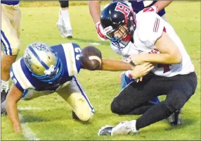  ?? Westside Eagle Observer/MIKE ECKELS ?? Kevin Sanchez (left) forces the ball out of the hands of a Hermits’ player during the Friday Decatur-Hermitage football game at Bulldog Stadium in Decatur. The ball was originally fumbled by the Hermit quarterbac­k and passed through several players’ hands before Hermitage finally recovered it.