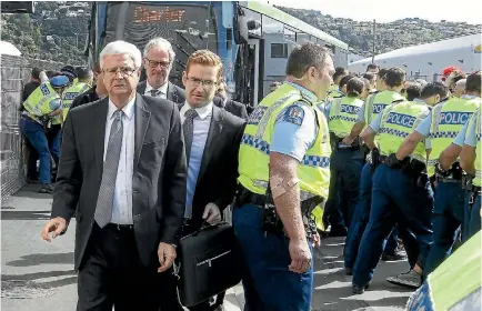  ?? PHOTO: KEVIN STENT/STUFF ?? Attendees at the defence forum at Westpac Stadium, Wellington, make their way off a bus under heavy police guard.