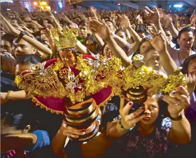  ?? FERDINAND EDRALIN/FREEMAN ?? Devotees raise images of Sto. Ni–o during a Mass at the Basilica del Sto. Ni–o that followed a penitentia­l procession in Cebu City yesterday.