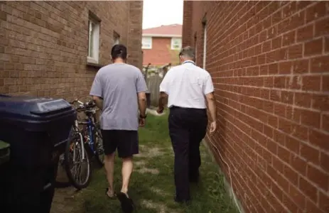  ?? CARLOS OSORIO/TORONTO STAR ?? Ward 39 Councillor Jim Karygianni­s walks into the backyard with a man at a residence he suspects is a rooming house.