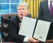  ?? KEVIN LAMARQUE / REUTERS ?? US President Donald Trump holds up his executive order on withdrawin­g from the Trans-Pacific Partnershi­p after signing it in the Oval Office of the White House in Washington, DC, on Monday.