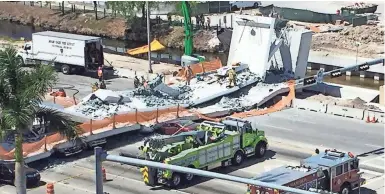  ?? ROBERTO KOLTUN/MIAMI HERALD VIA AP ?? Emergency personnel respond to a collapsed pedestrian bridge Thursday at Florida Internatio­nal University in Sweetwater. The new pedestrian bridge collapsed onto a highway, crushing several vehicles.