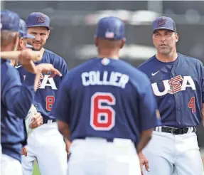  ?? CHRISTIAN PETERSEN/GETTY IMAGES ?? Team USA manager Mark Derosa (4) talks with his players during a practice ahead of the World Baseball Classic.