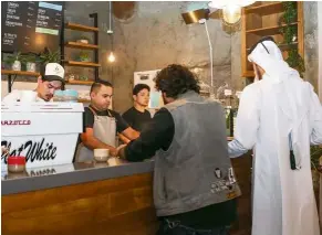  ??  ?? Here for a cuppa: Customers collecting their orders at Flat White. — AFP